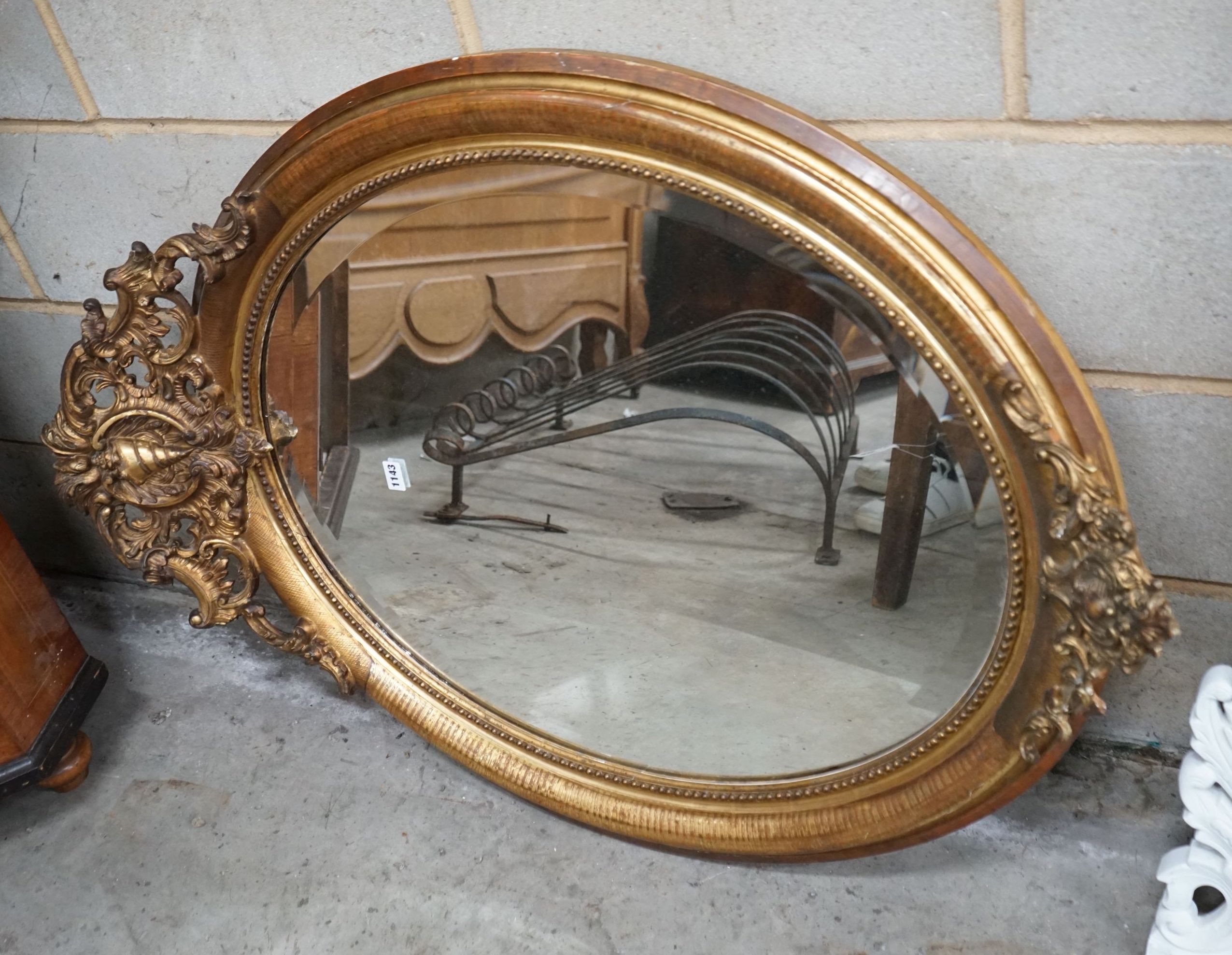 A 19th century French oval giltwood and gesso wall mirror with pierced 'C' scroll and shell pediment, width 78cm, height 118cm